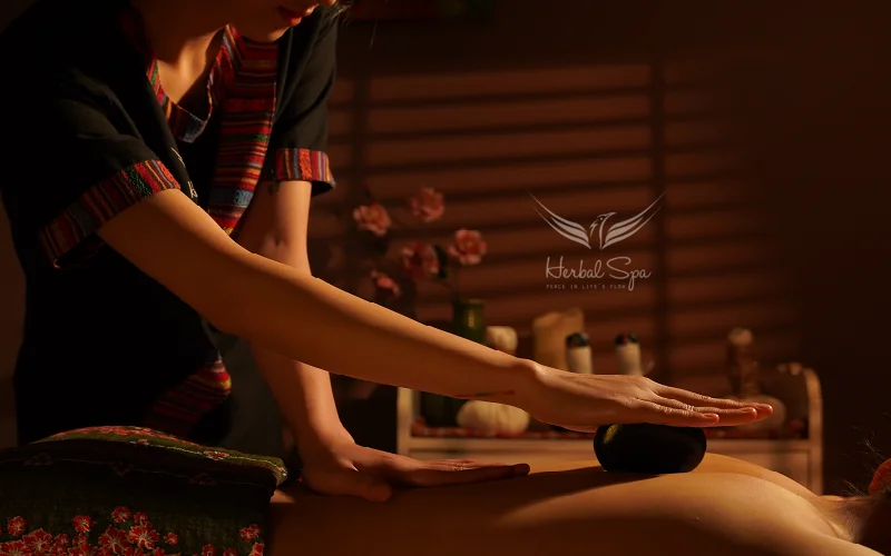 Gentle massage movements with hot stones soothe muscles and reduce pain