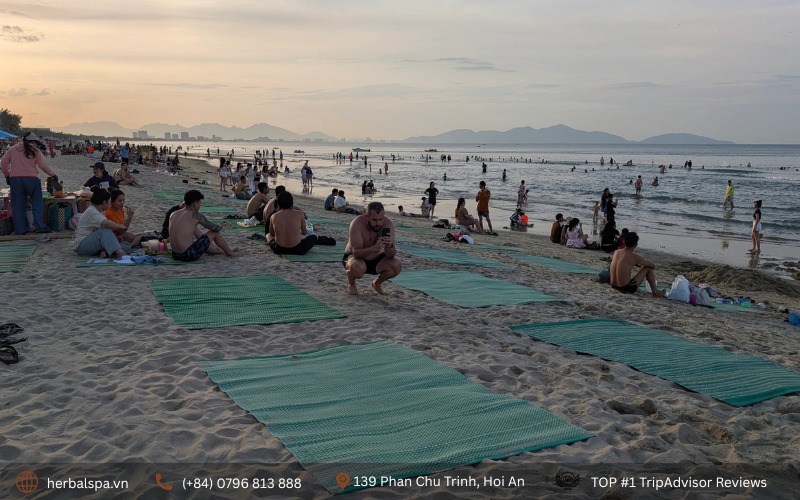 Tourists on An Bang Beach, looking along the coast toward Da Nang