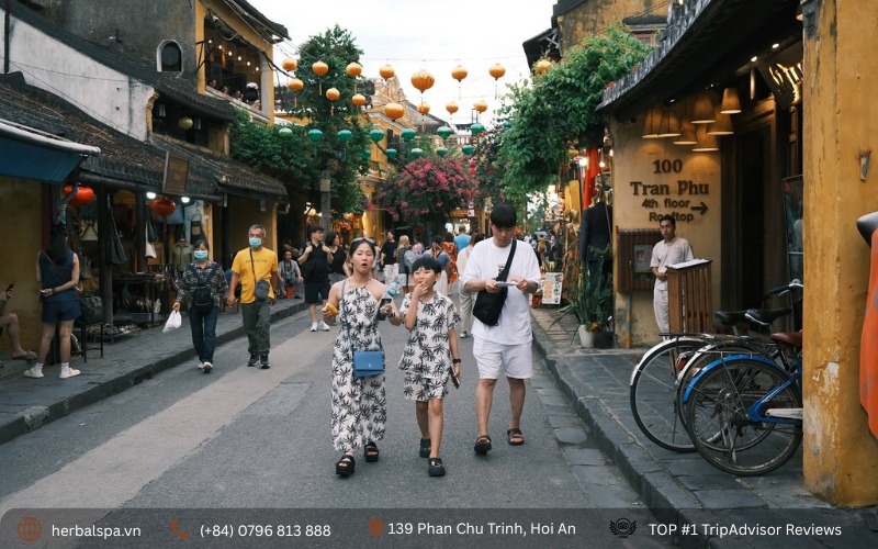 Families walk along Tran Phu Street on foot to explore Hoi An Ancient Town